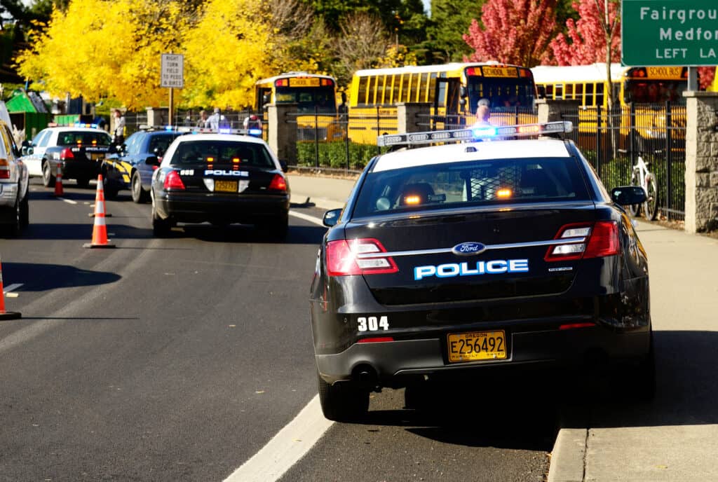 ROSEBURG, OR - OCTOBER 16: Police cars and school buses at an accident at the entrance of the High School loading zone in Roseburg Oregon, October 16, 2012